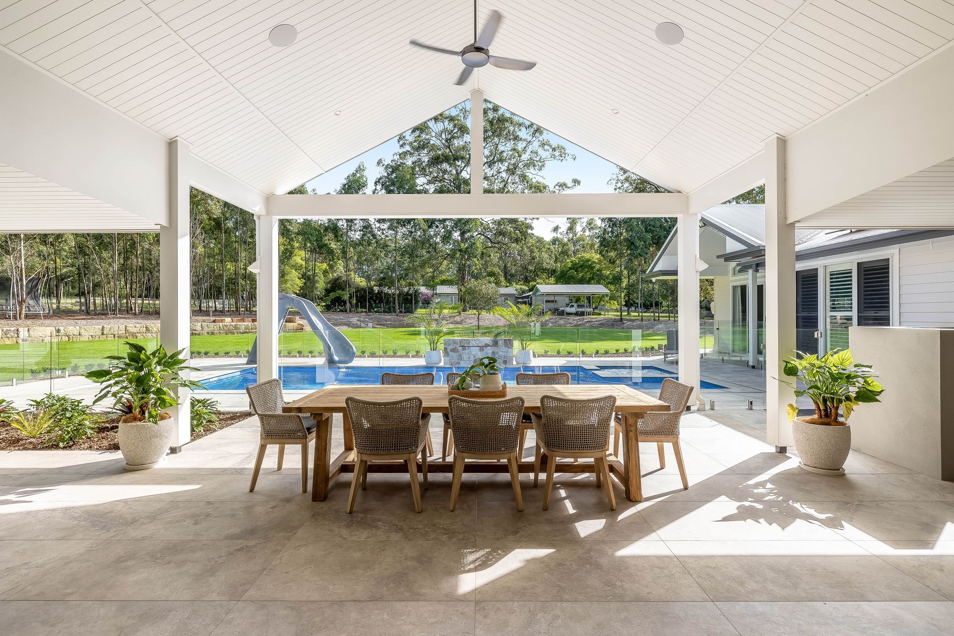 A patio with a table and chairs and a ceiling fan. — Windamere Homes in Highfields, QLD