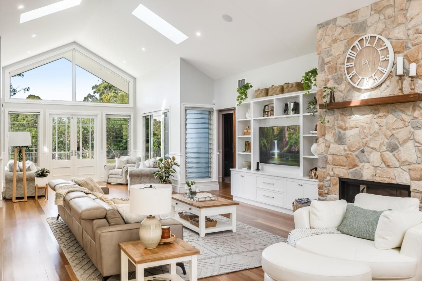 A Living Room With a Fireplace and a Clock on the Wall — Windamere Homes in Highfields, QLD