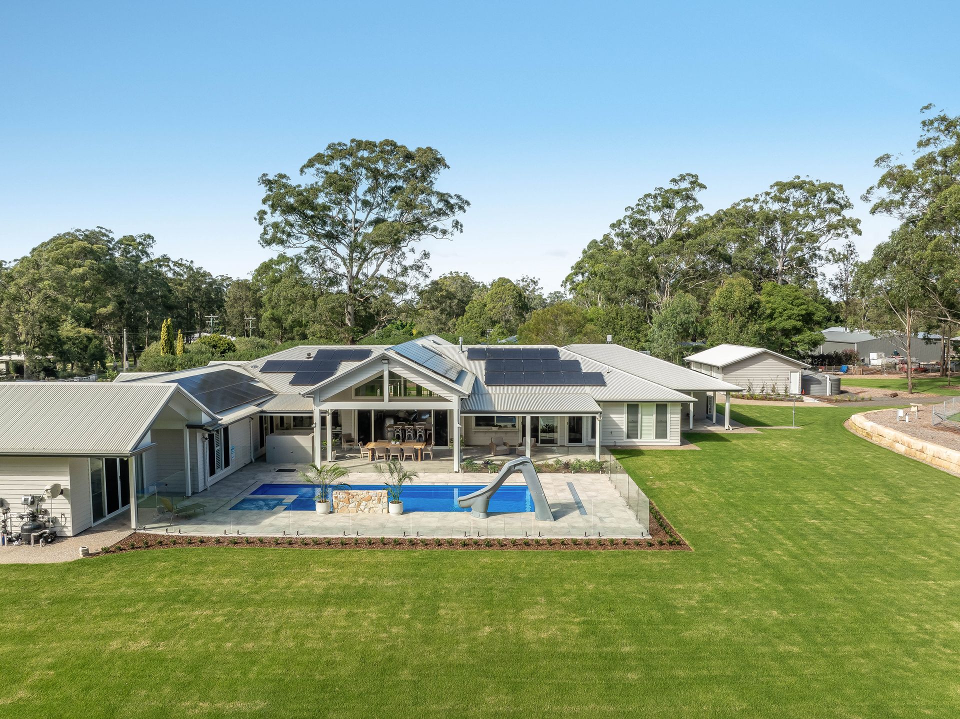 An aerial view of a large house with a swimming pool in the backyard. — Windamere Homes in Highfields, QLD