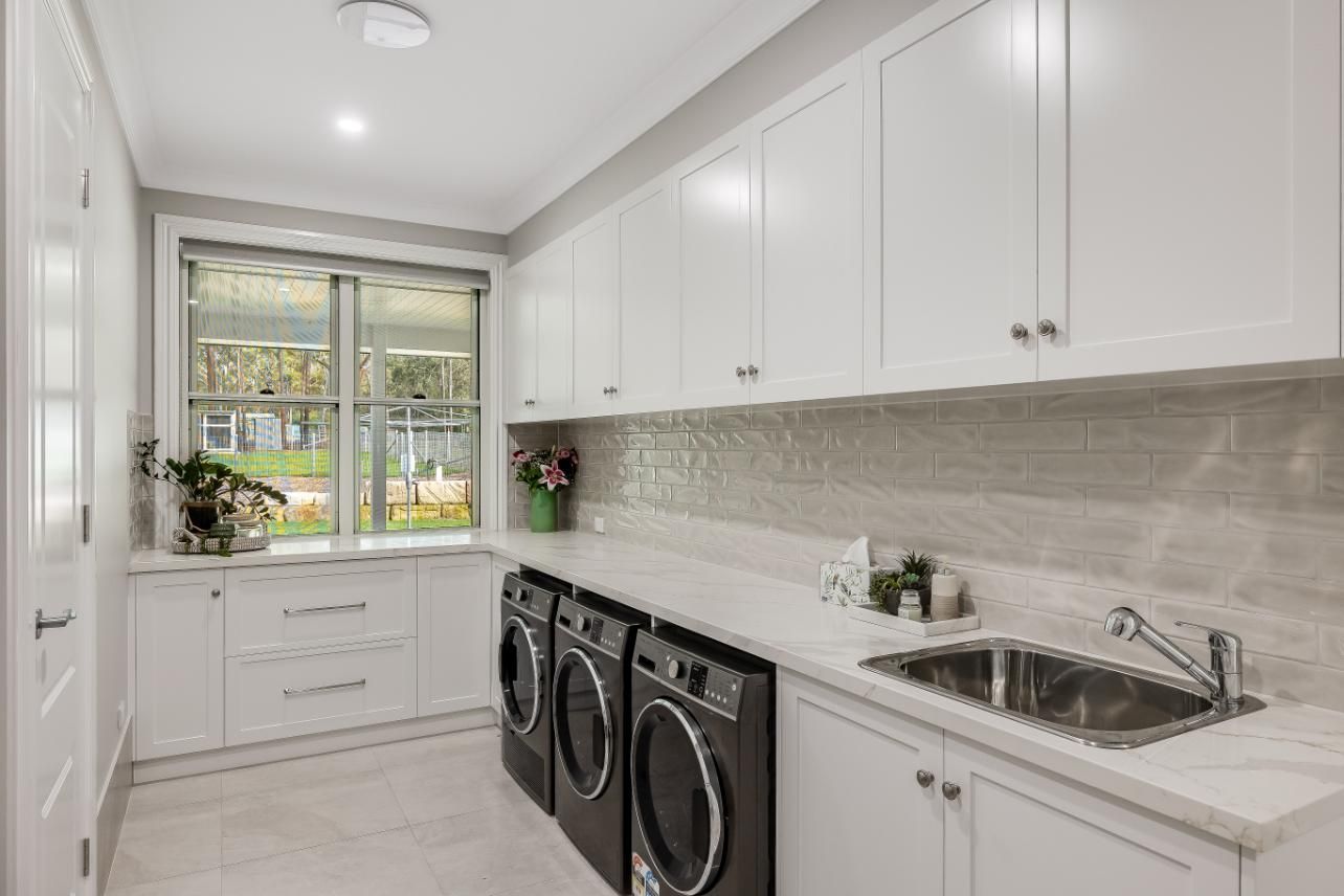 A Laundry Room With a Washer and Dryer and a Sink — Windamere Homes in Highfields, QLD
