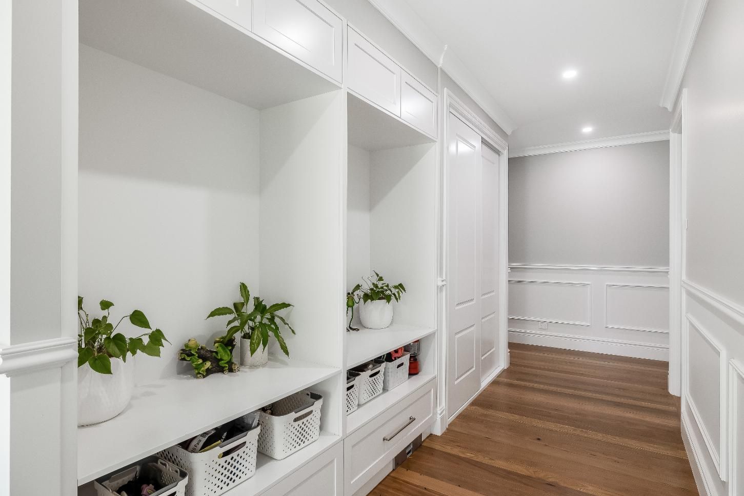 A Hallway With White Shelves and Wooden Floors in a House — Windamere Homes in Highfields, QLD