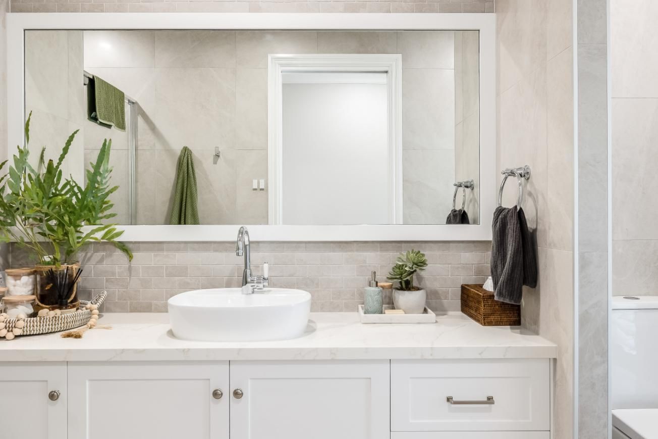 A Bathroom With a Sink , Mirror and Cabinets — Windamere Homes in Highfields, QLD