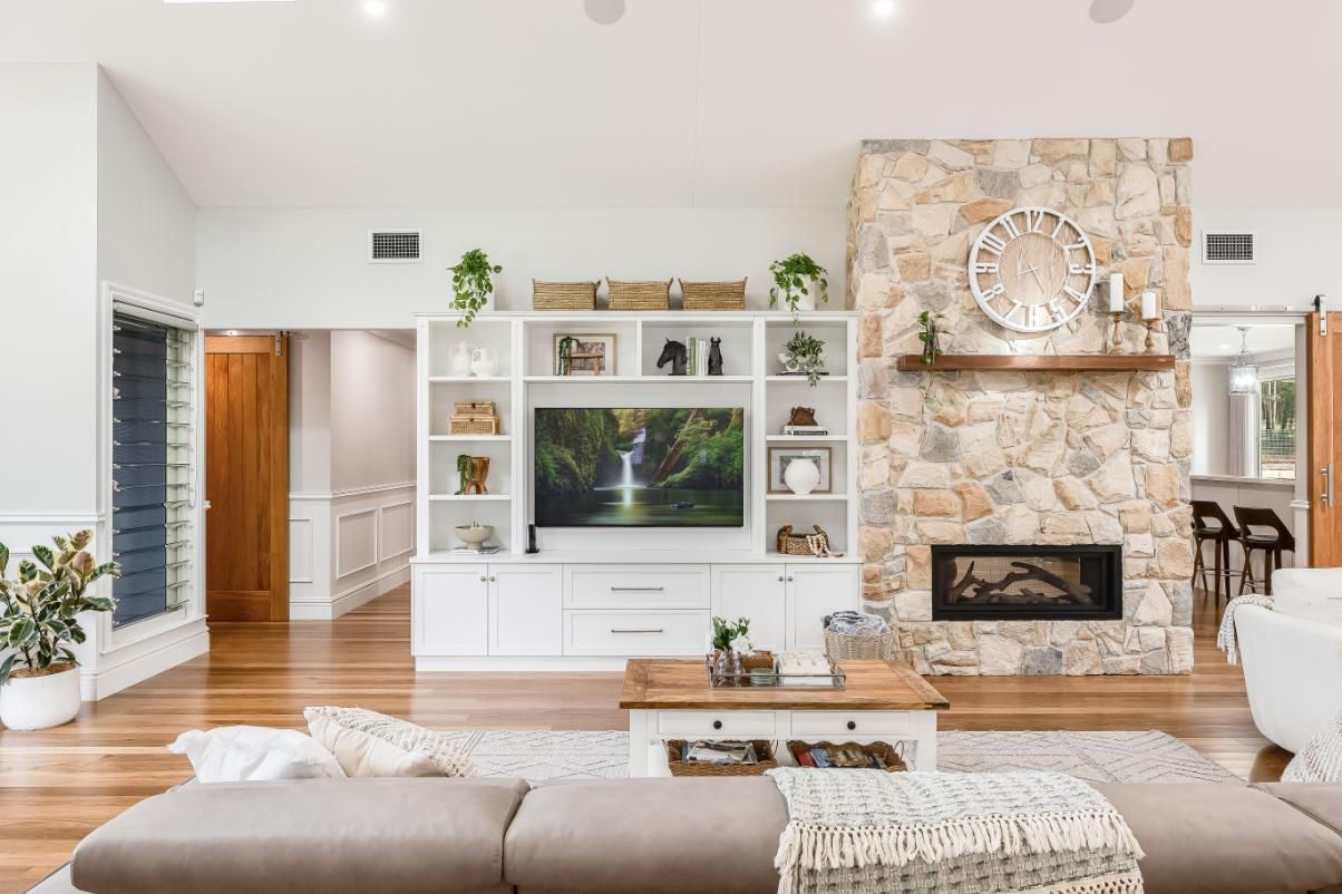 A Living Room With a Fireplace and a Flat Screen Tv — Windamere Homes in Highfields, QLD