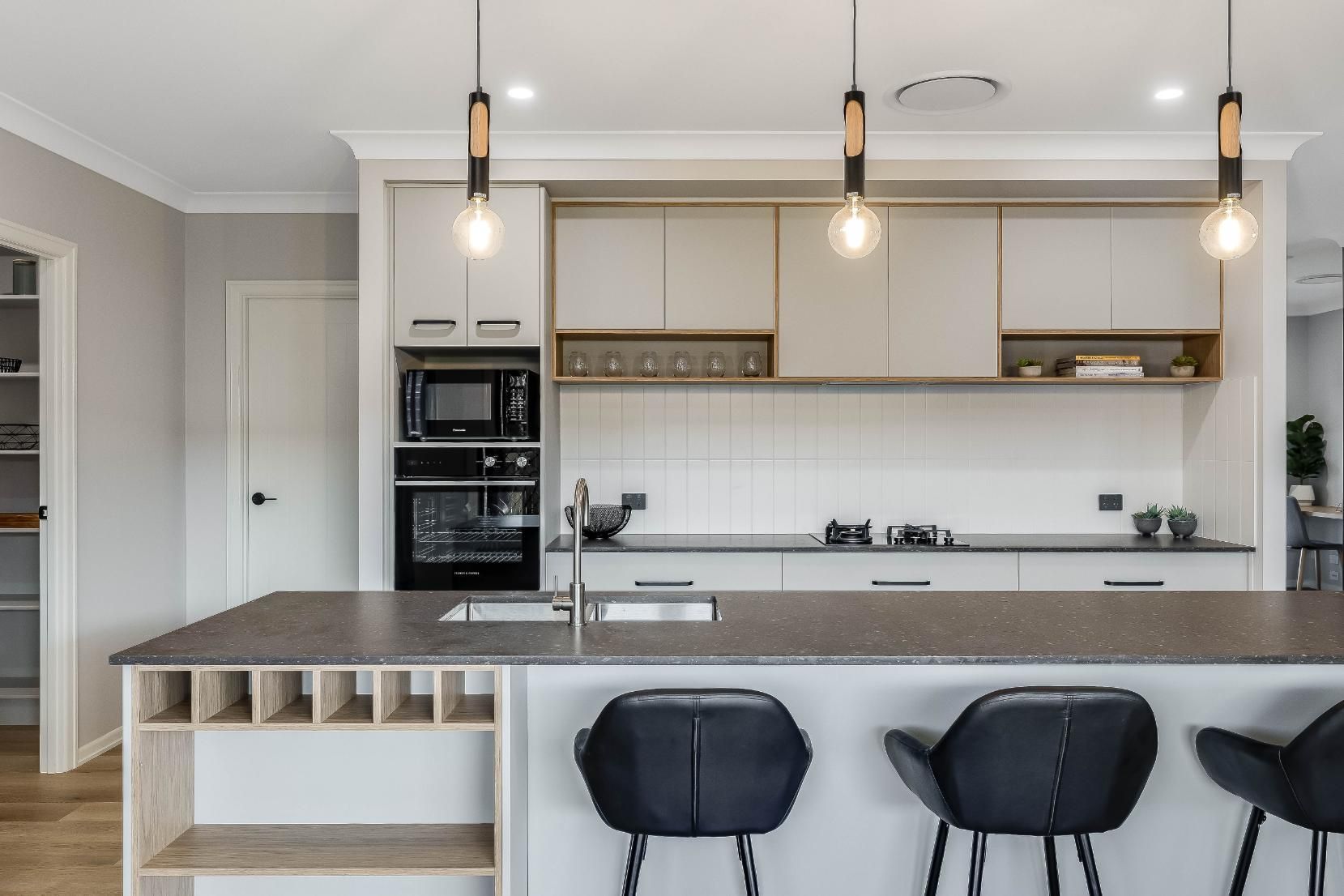 A Kitchen With White Cabinets and a Granite Counter Top — Windamere Homes in Highfields, QLD