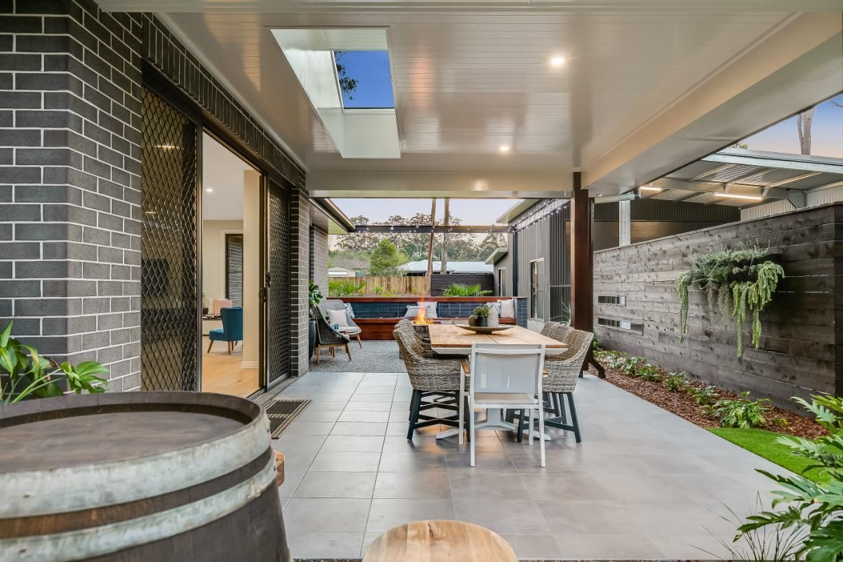A Patio With a Table and Chairs and a Barrel — Windamere Homes in Highfields, QLD