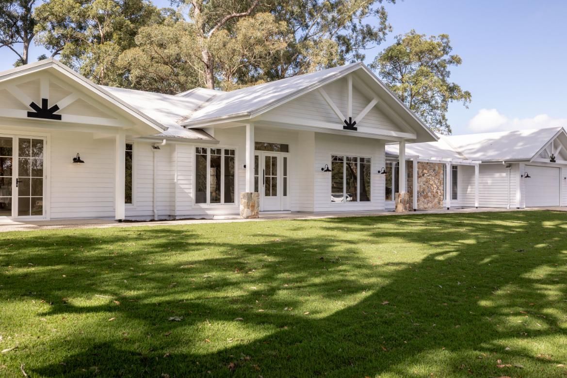 A Large White House With a Lush Green Lawn — Windamere Homes in Highfields, QLD