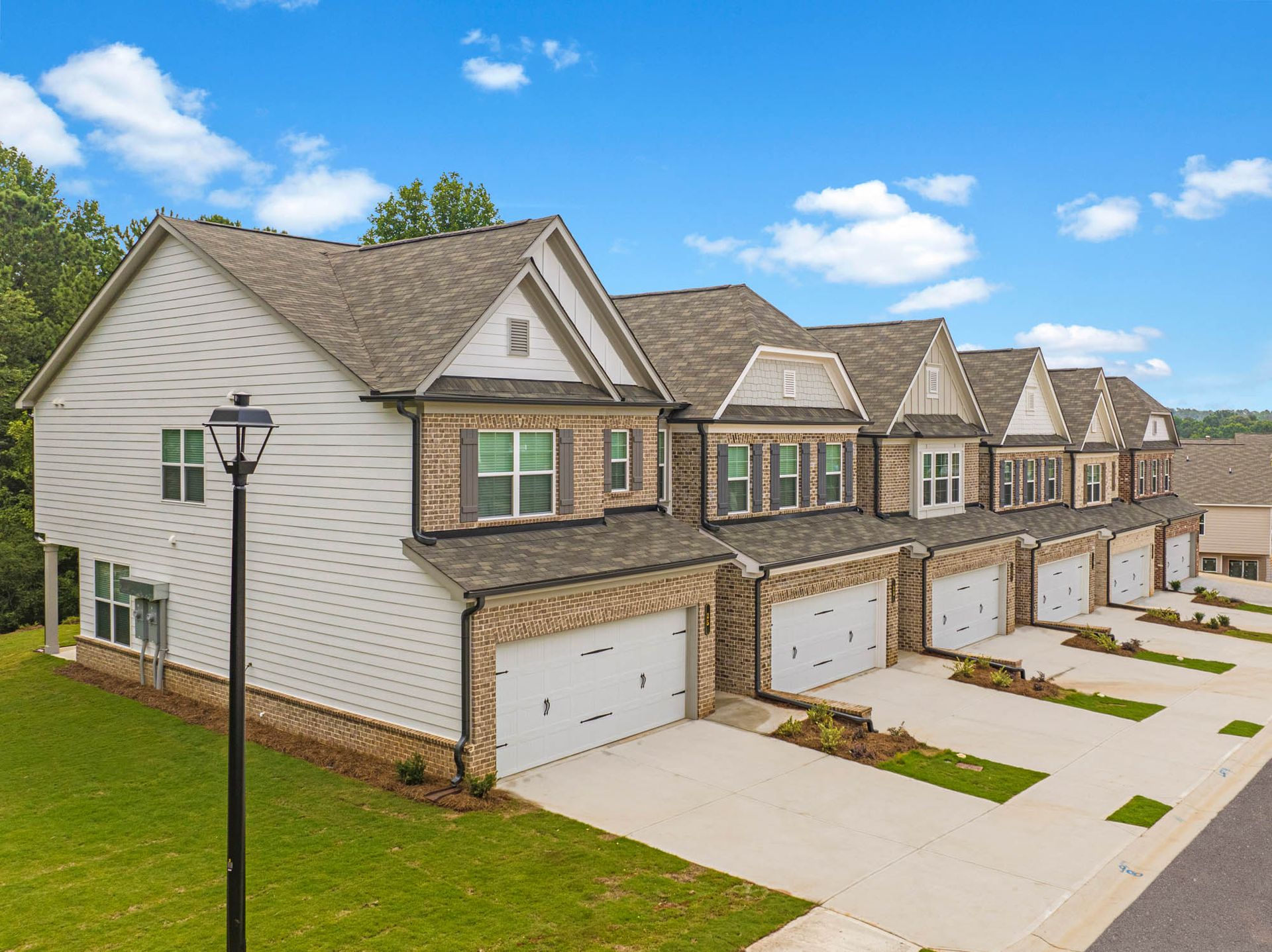 A row of houses with garages and a street light in front of them at Collins Place.