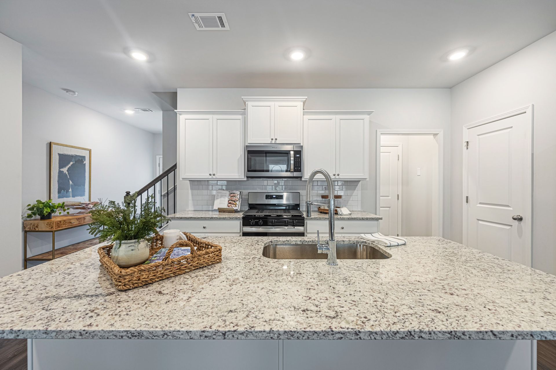 A kitchen with granite counter tops , stainless steel appliances , and white cabinets at Collins Place.