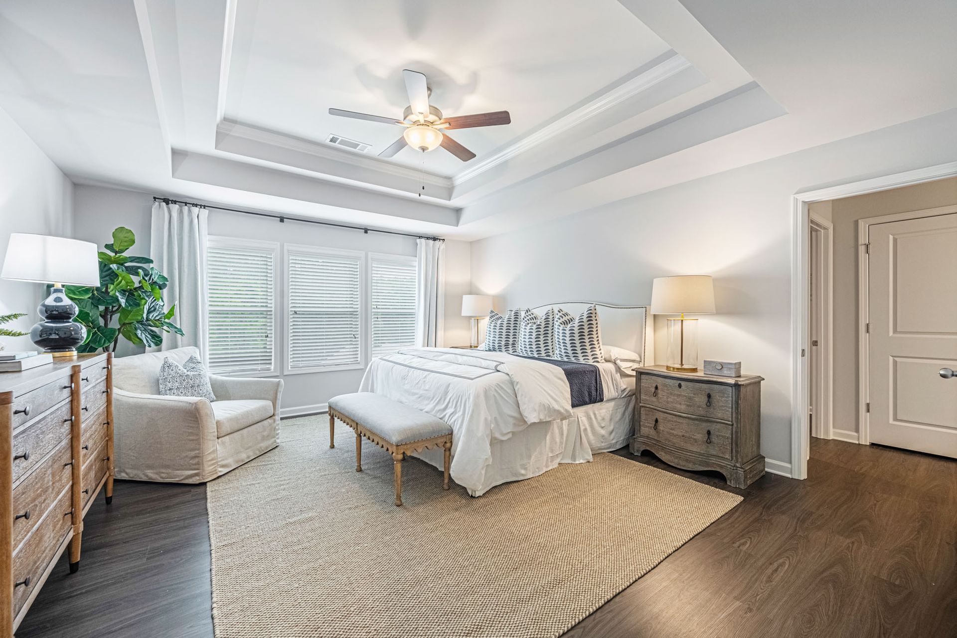 A large bedroom with a ceiling fan and a king size bed at Collins Place.