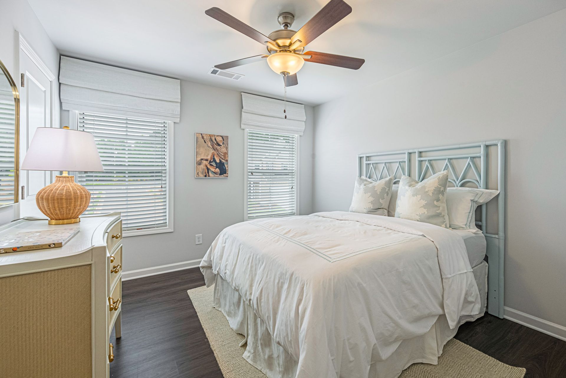 A bedroom with a bed , dresser , lamp and ceiling fan at Collins Place.