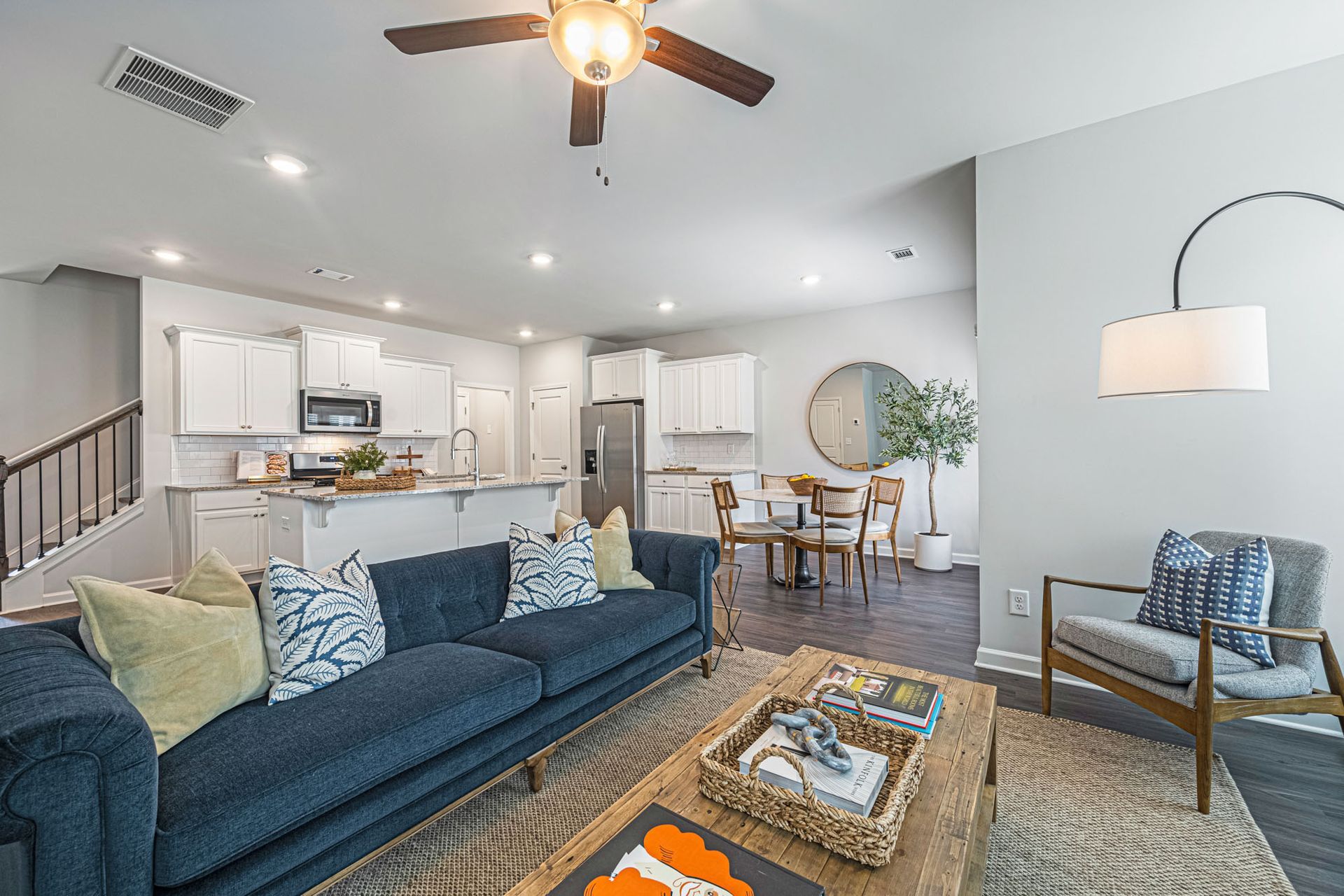 A living room with a blue couch and a ceiling fan at Collins Place.