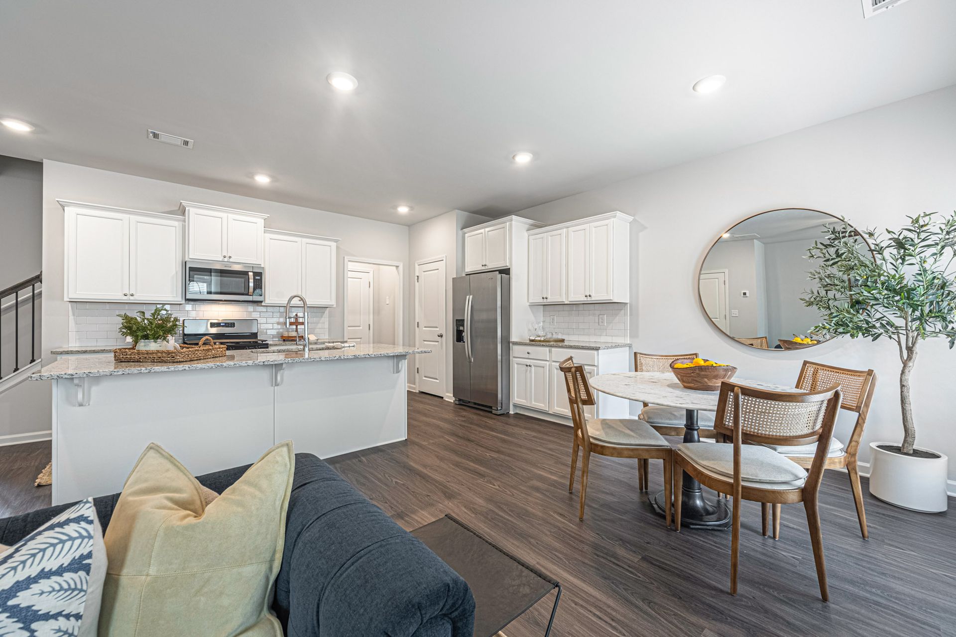 A living room with a couch , table , chairs and a kitchen at Collins Place.