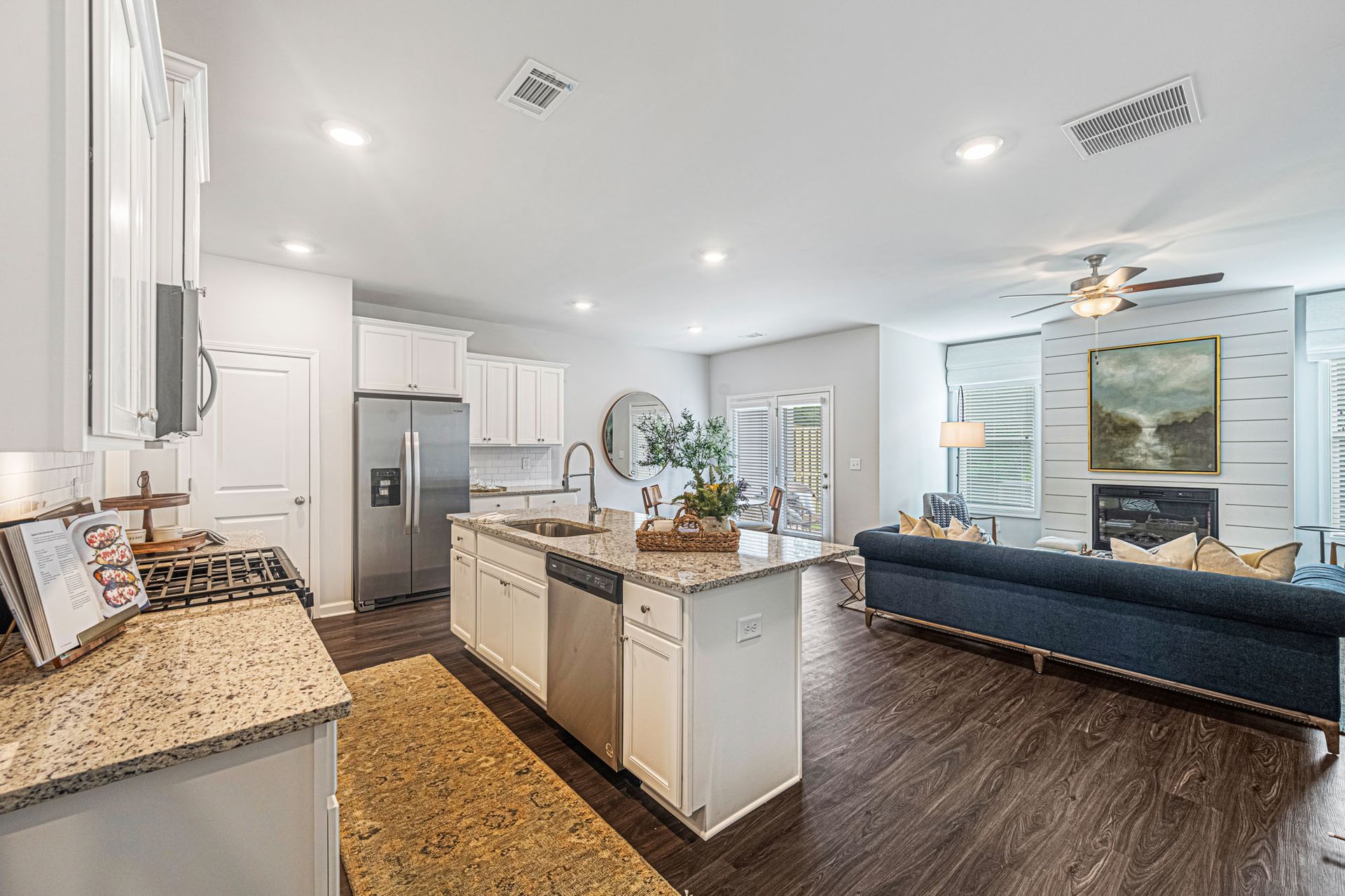 A kitchen and living room in a house with a large island in the middle at Collins Place.