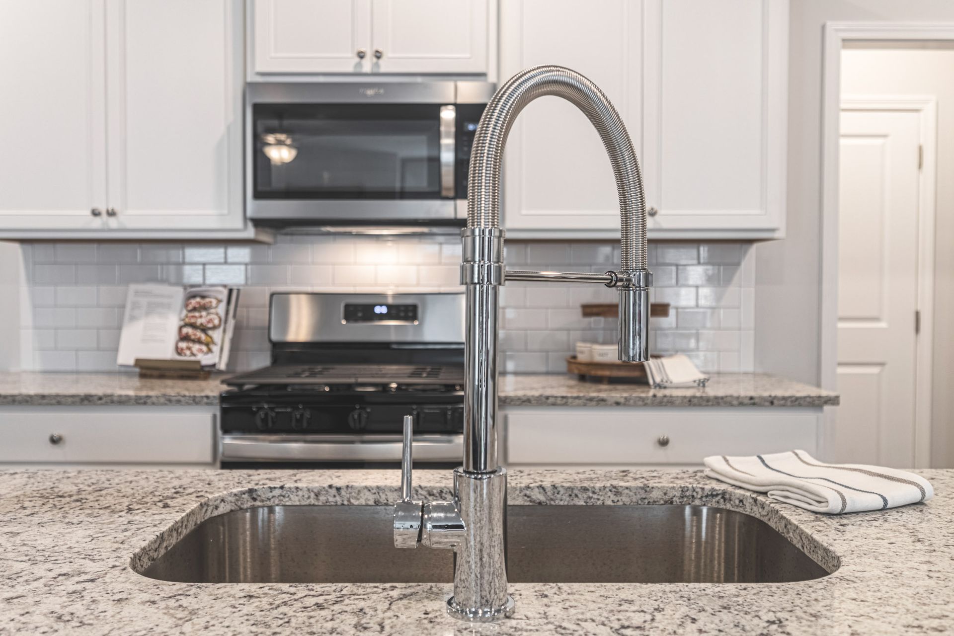 A kitchen with a sink , stove and microwave at Collins Place.