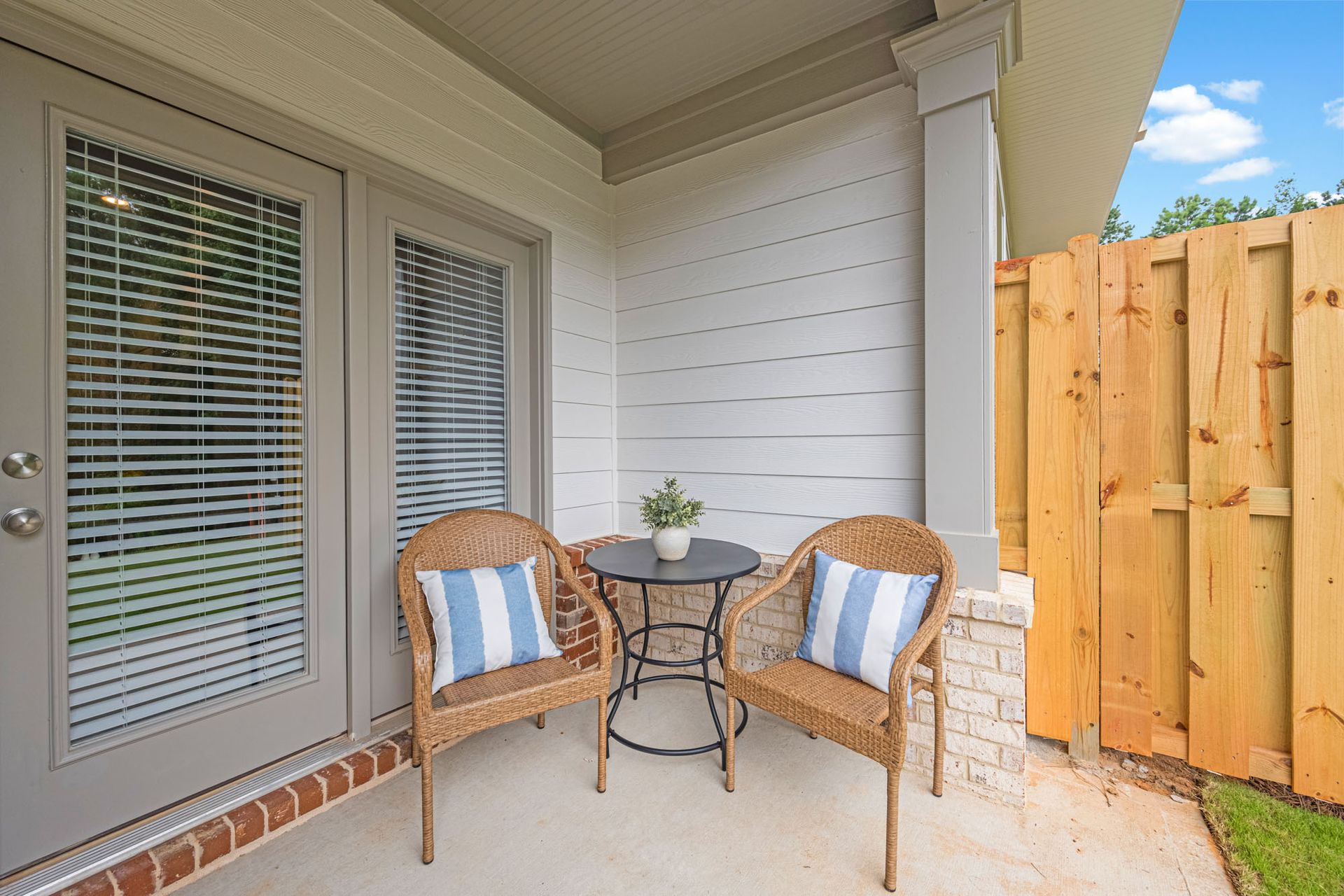 There is a patio with two chairs and a table at Collins Place.