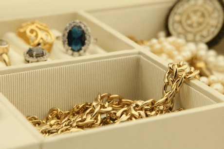 A jewelry box filled with necklaces , rings  and pearls.