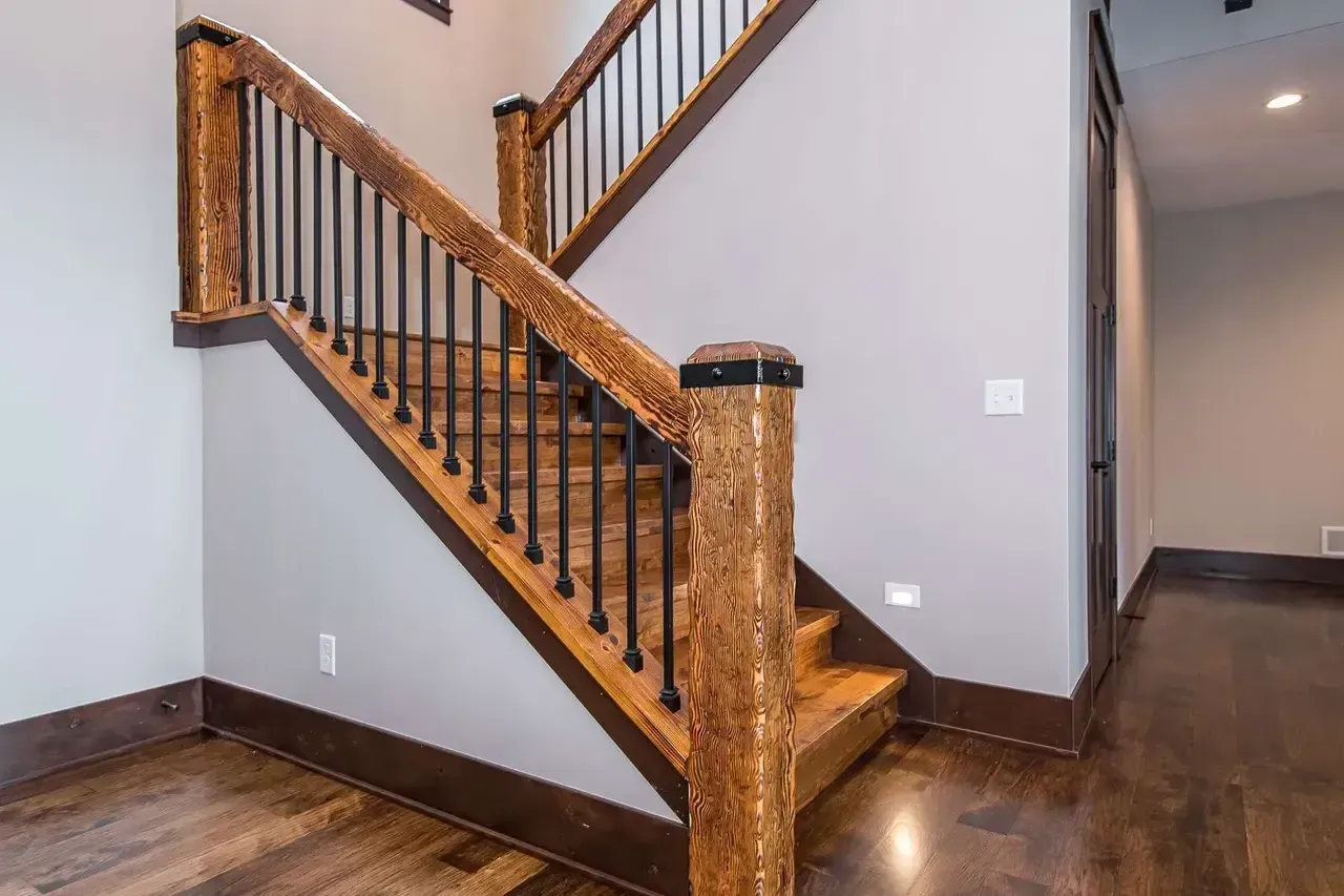 A wooden staircase with a metal railing in a house