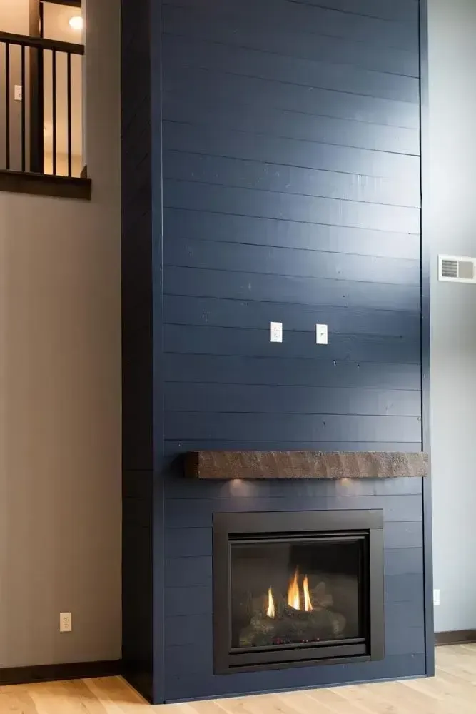 a fireplace with a blue wall behind it