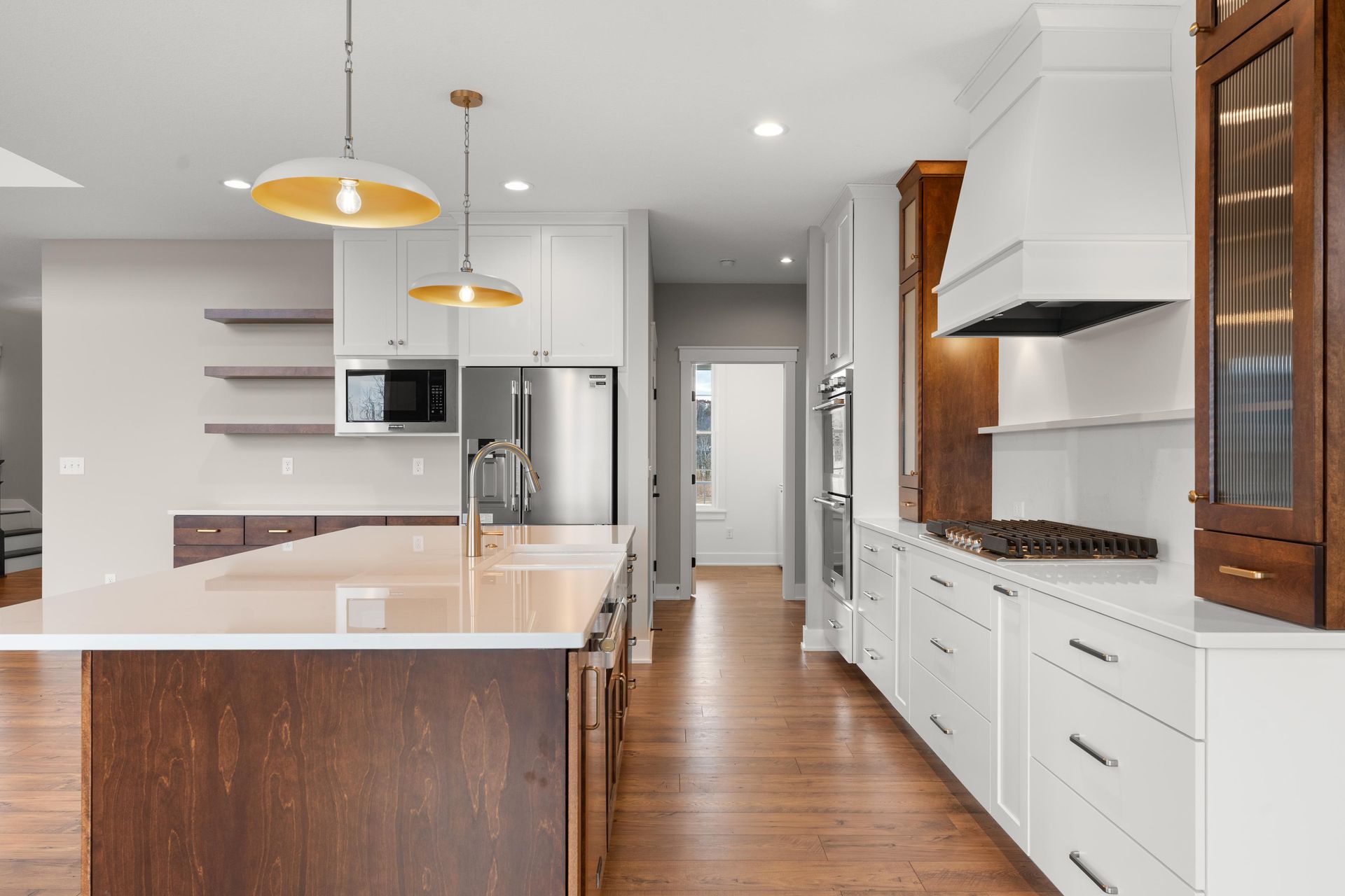 Modern kitchen with island, stainless steel appliances, and wood and white cabinetry.