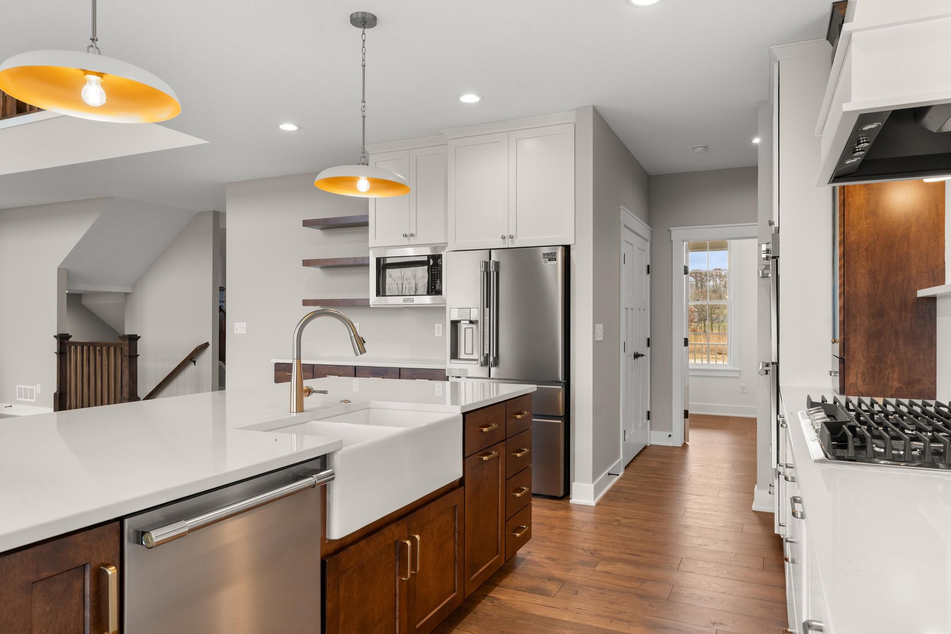 Kitchen with white cabinets, stainless steel appliances, and wood floors.