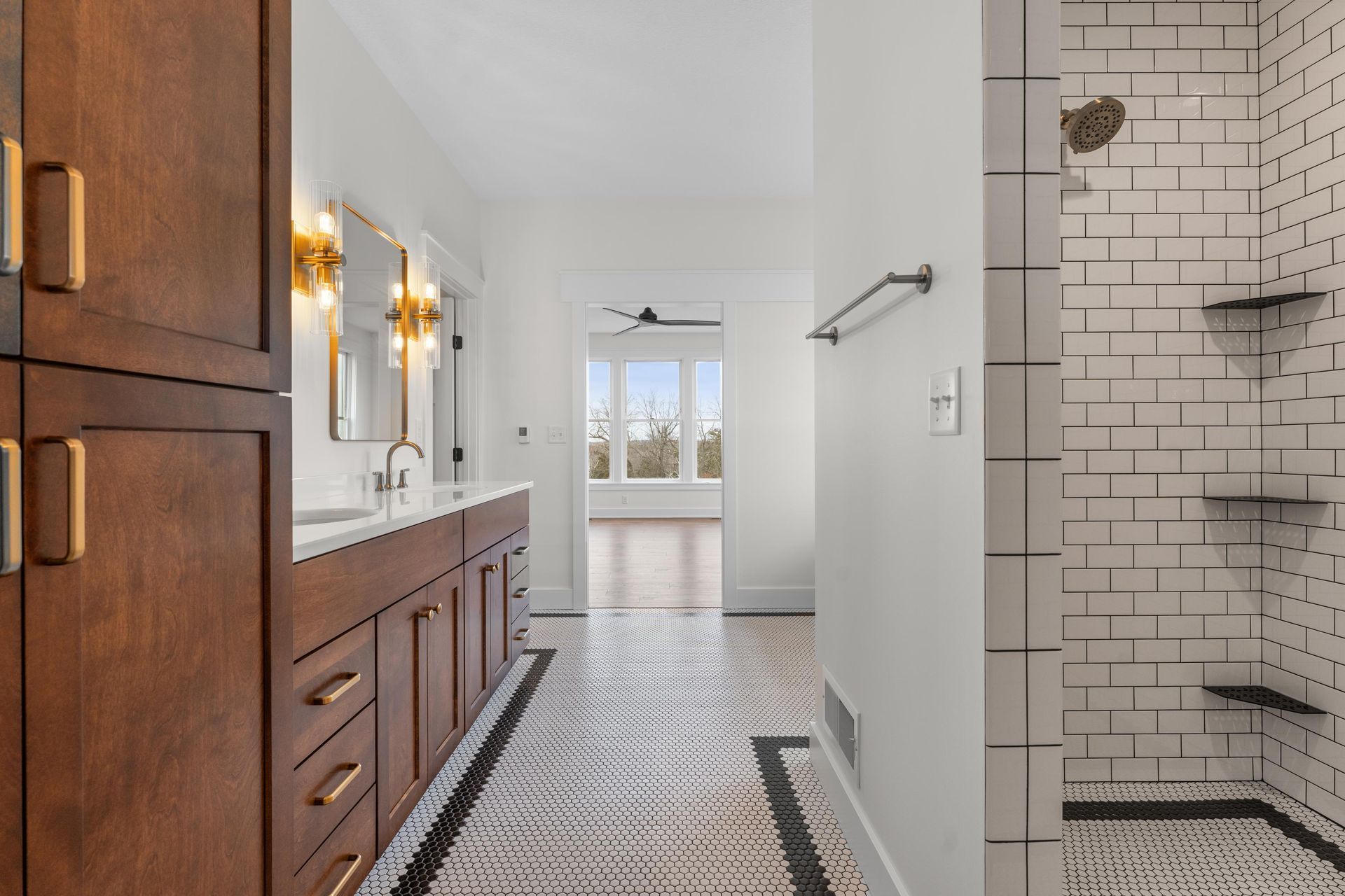 Bathroom with dark wood vanity, white tile shower, and patterned floor.