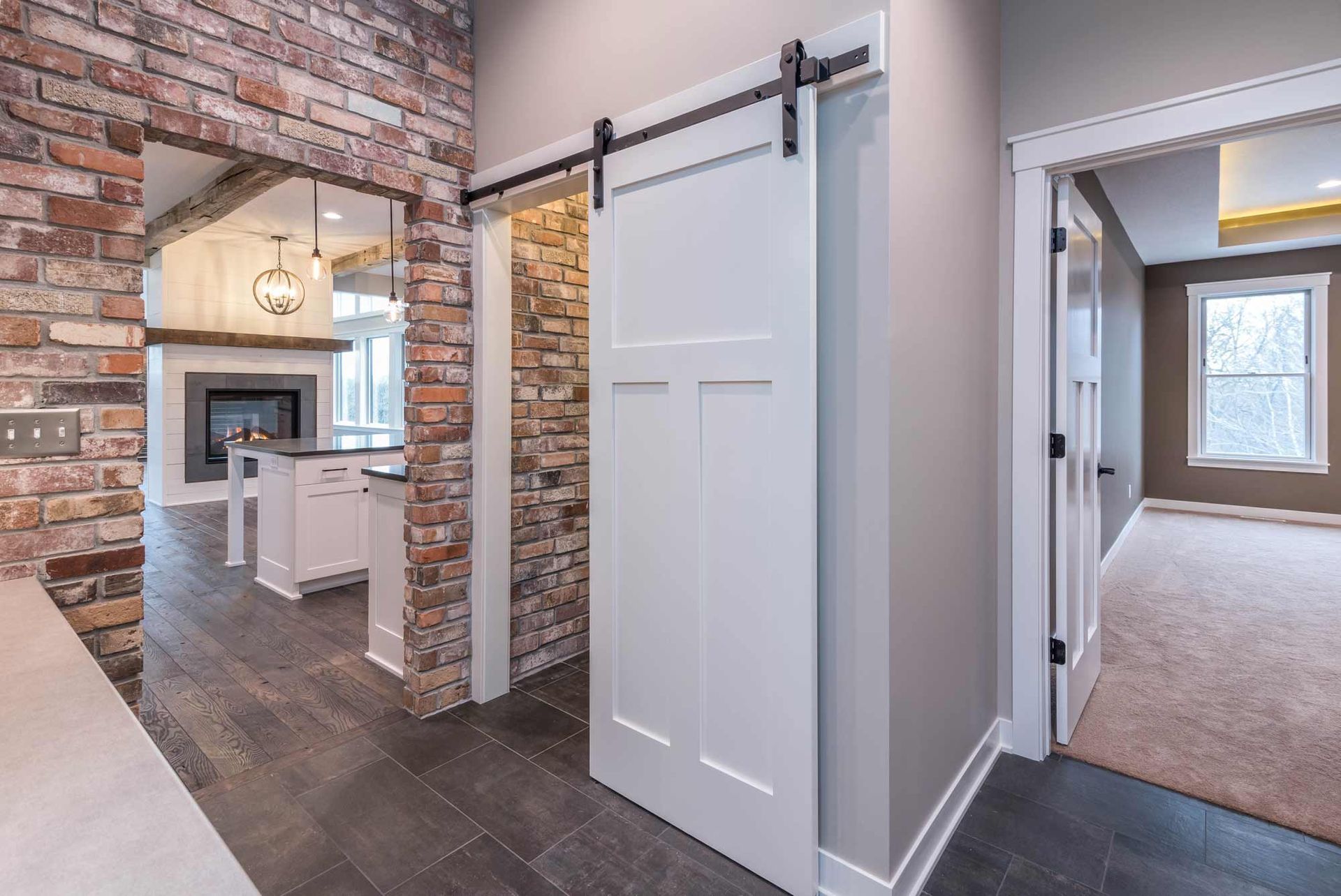 A sliding barn door is between two rooms in a house