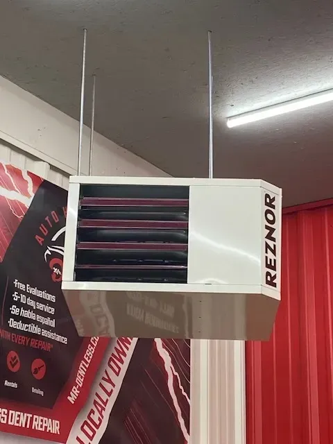 A reznor heater is hanging from the ceiling in a room