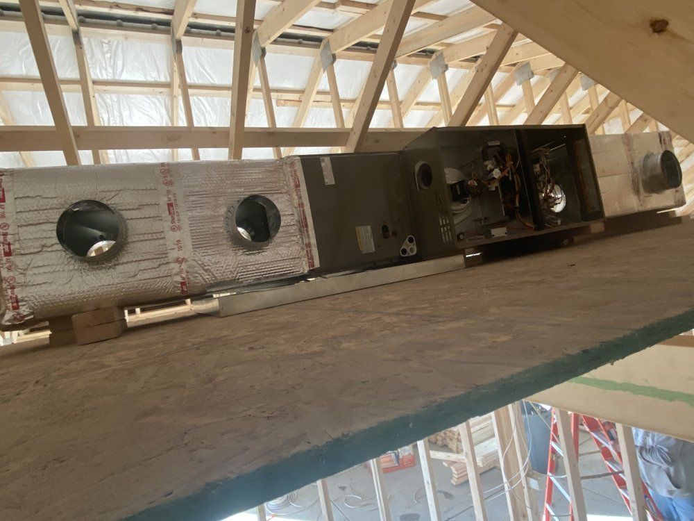 A building under construction with a lot of pipes hanging from the ceiling.