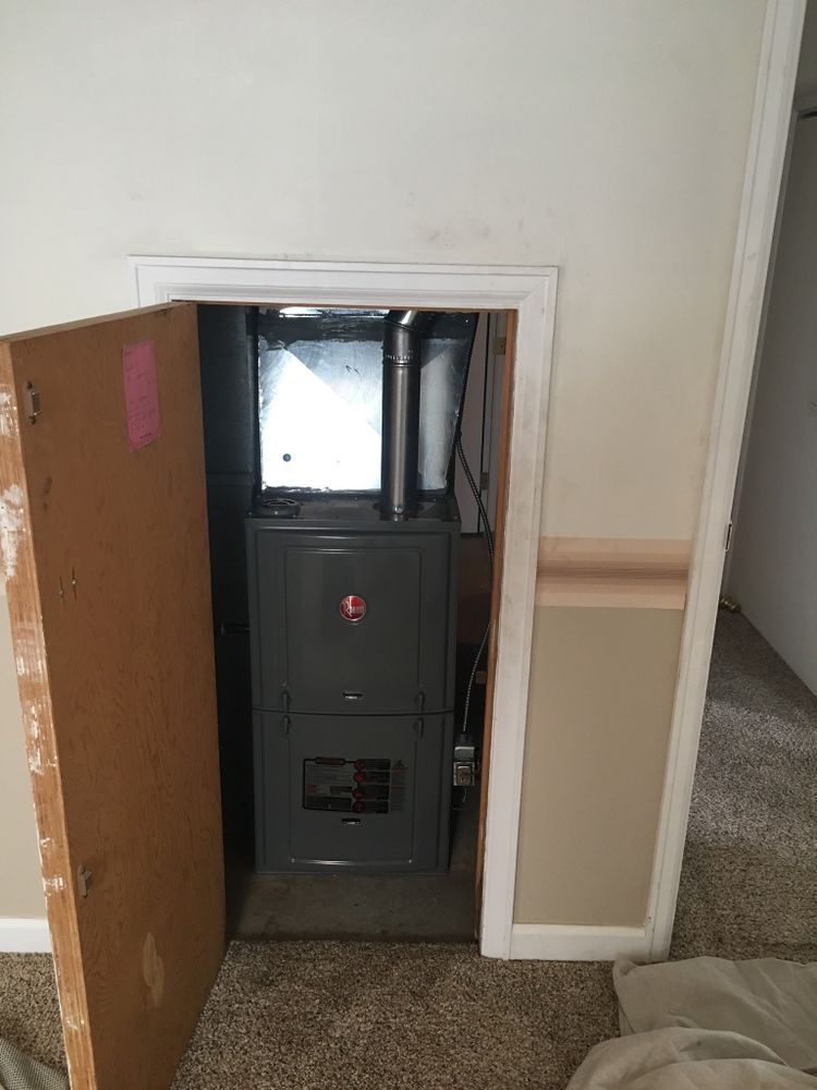 A furnace is sitting in a closet in a room.