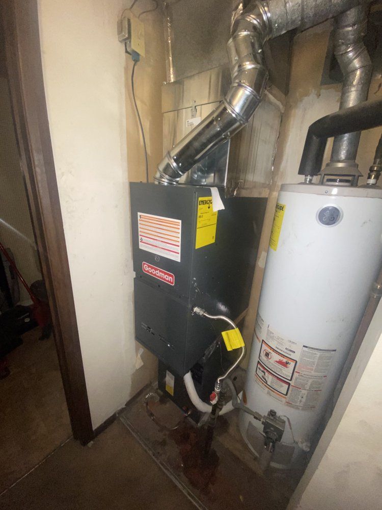 A water heater is sitting next to a heater in a room.