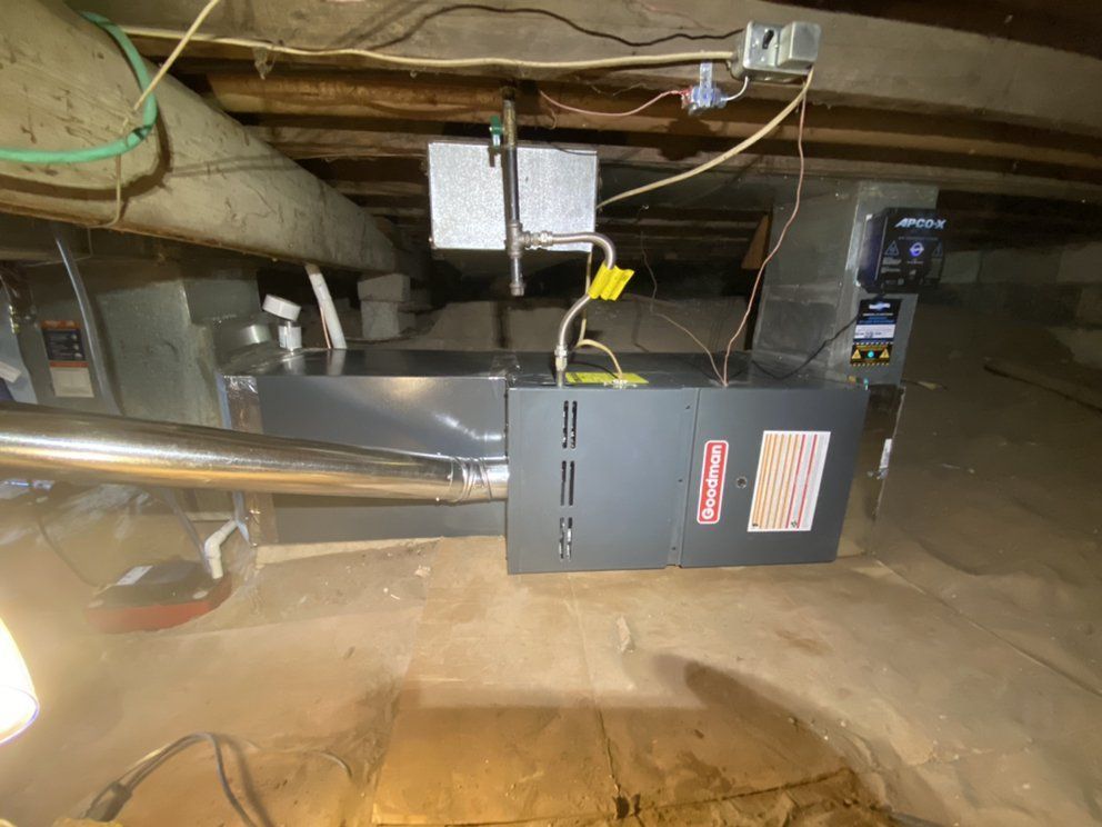 An air conditioner is hanging from the ceiling of a basement.
