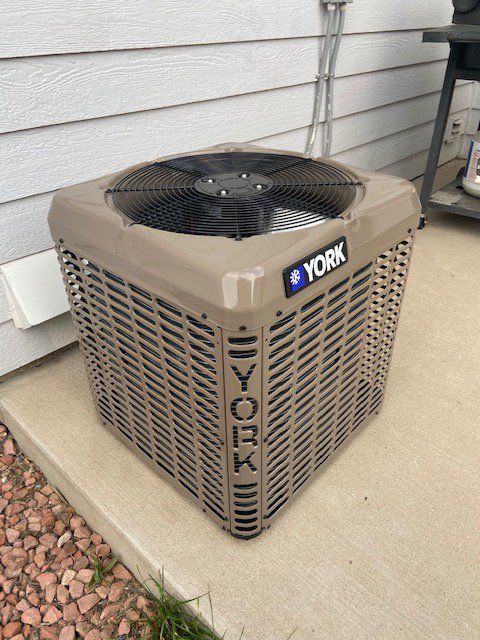 A york air conditioner is sitting outside of a house