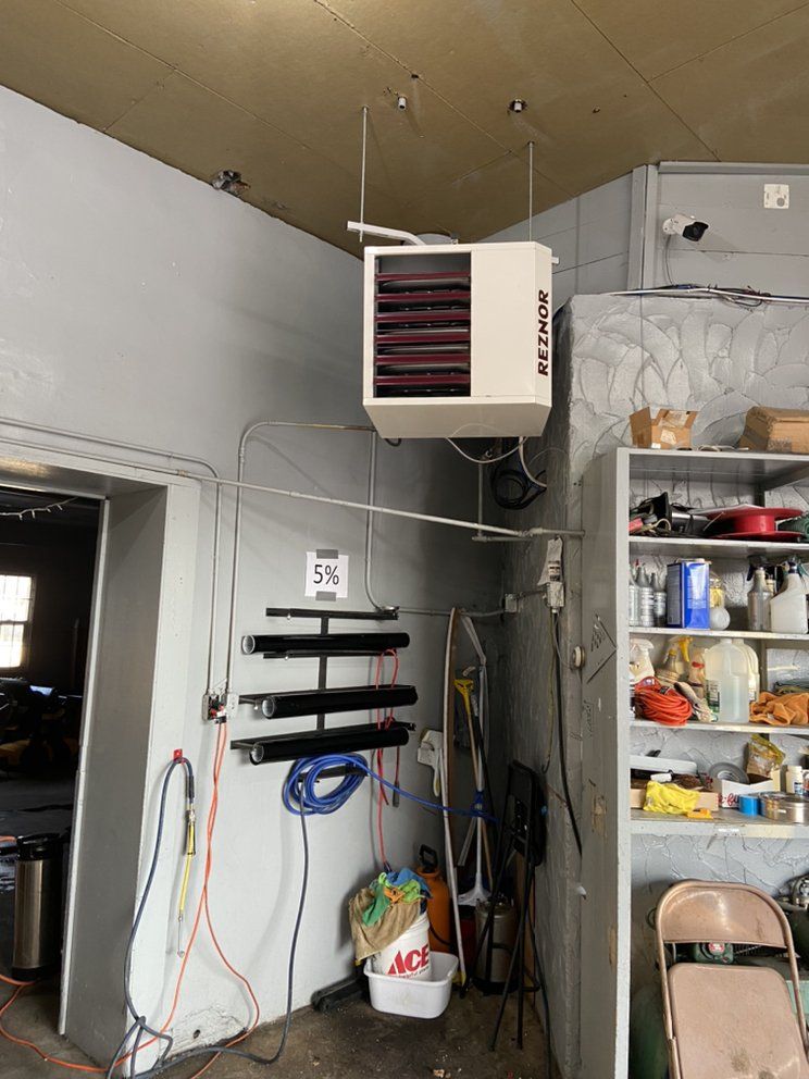 A room with a heater hanging from the ceiling.