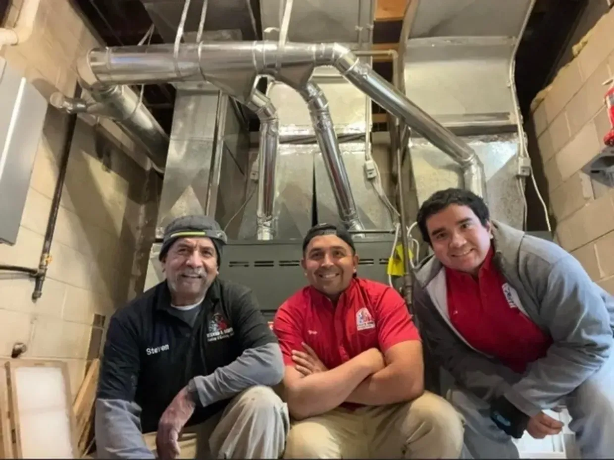 Three men are posing for a picture in a room