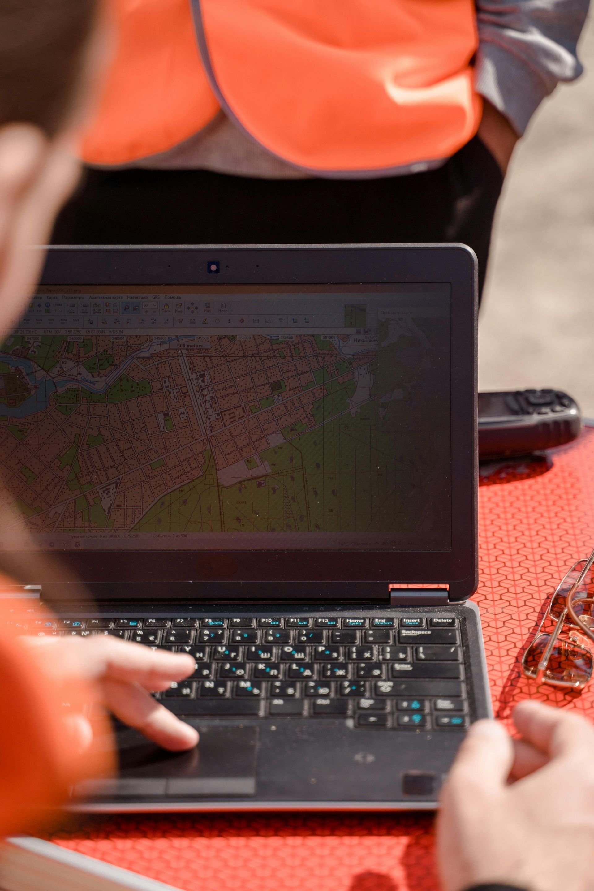 A person is using a laptop computer with a map on the screen.