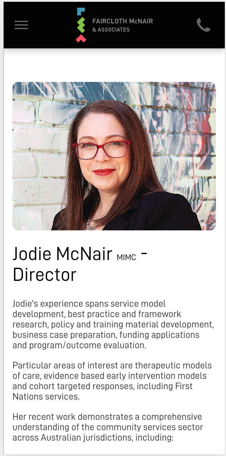 A woman wearing glasses and a black jacket is standing in front of a wall.Jodie McNair from Faircloth McNair & associates