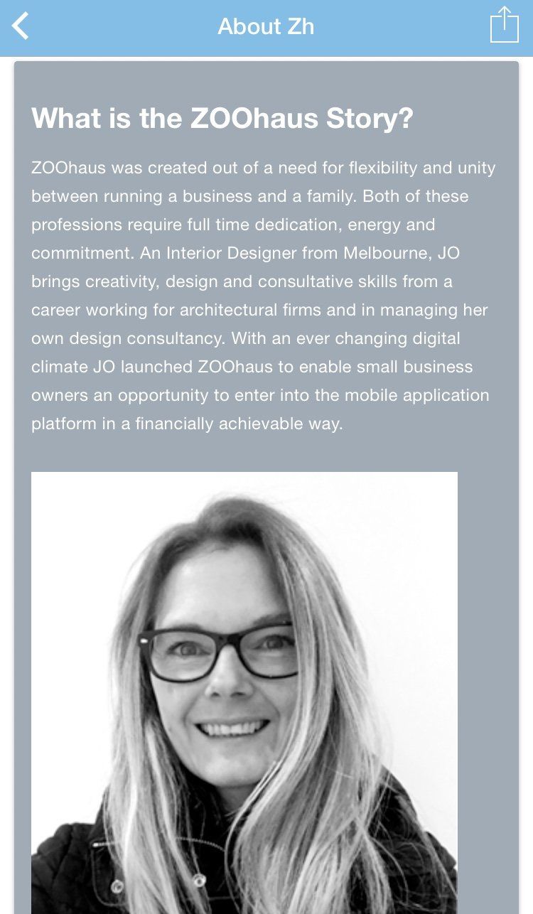 A woman wearing glasses is smiling in a black and white photo.