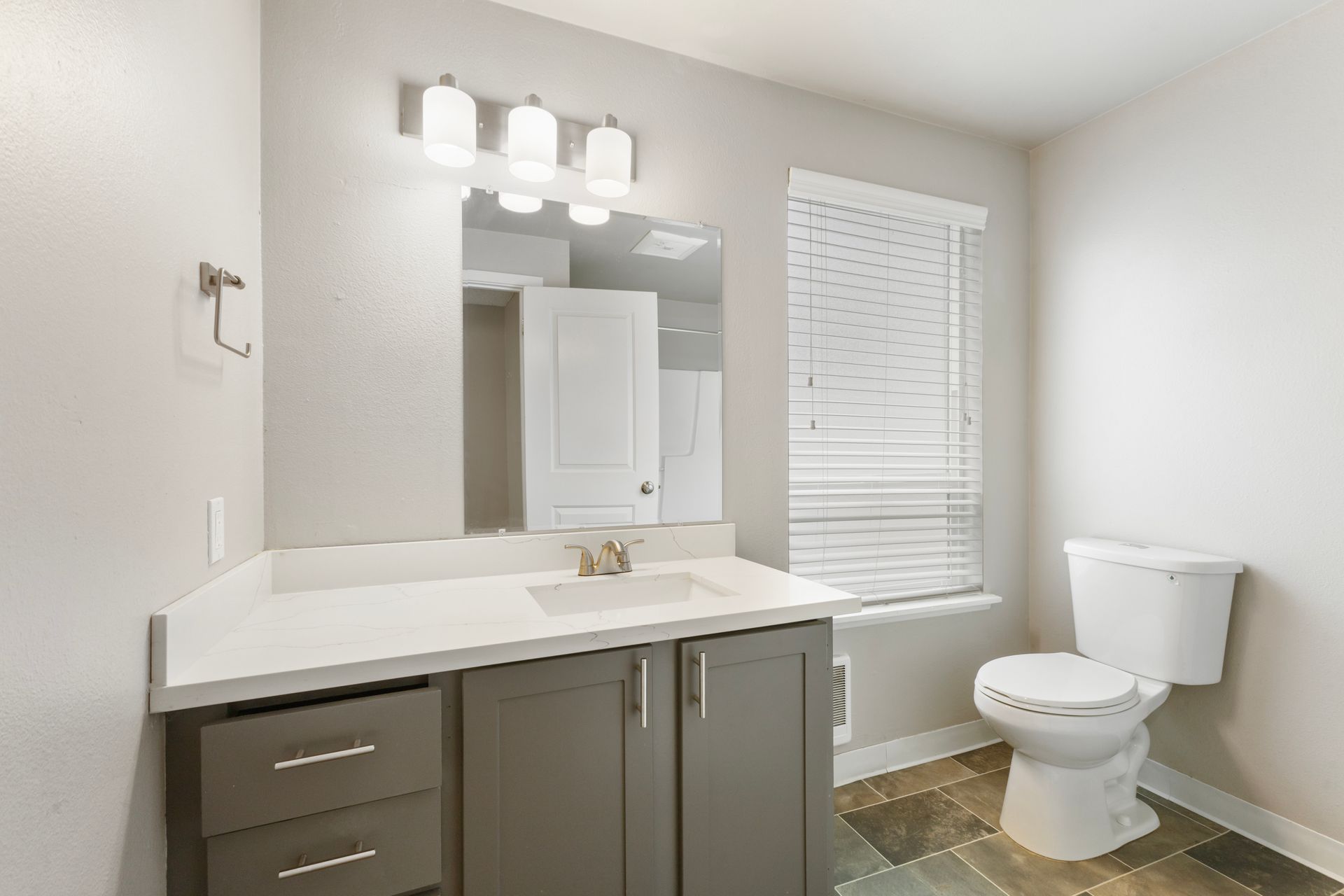 A bathroom with a sink , toilet and mirror.