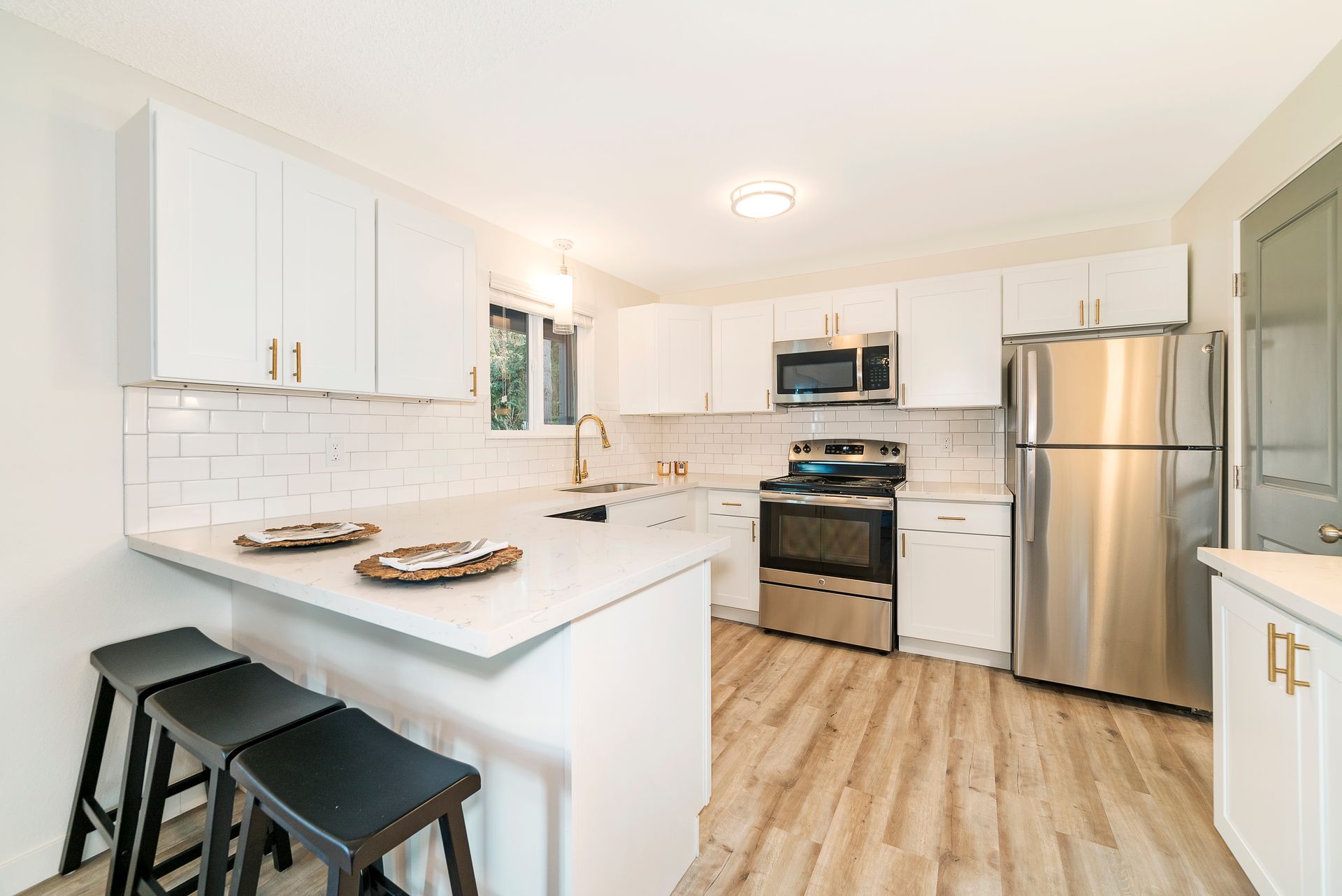 A kitchen with white cabinets and stainless steel appliances