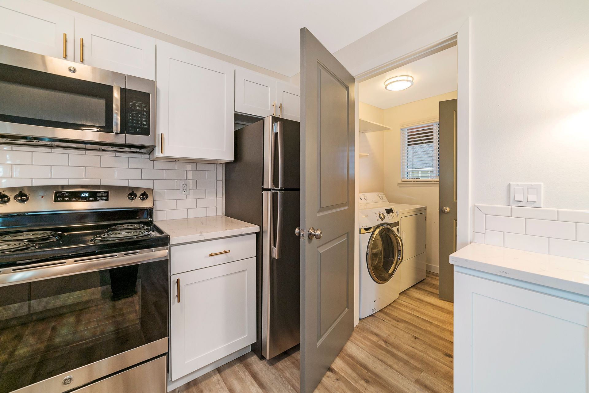A kitchen with stainless steel appliances and white cabinets