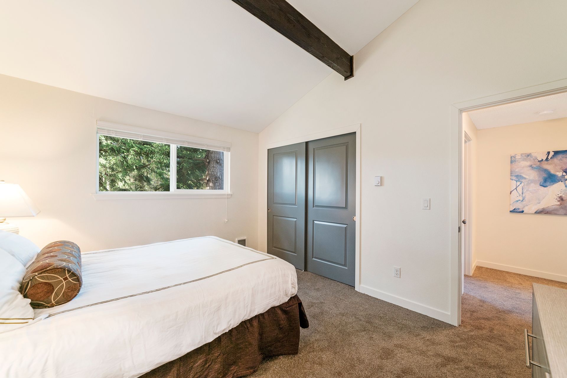 A bedroom with a bed , closet , and window.