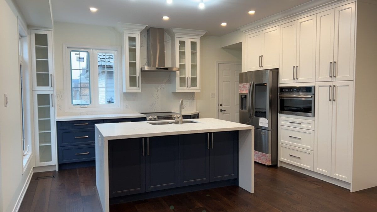 A kitchen with white cabinets and a large island in the middle.