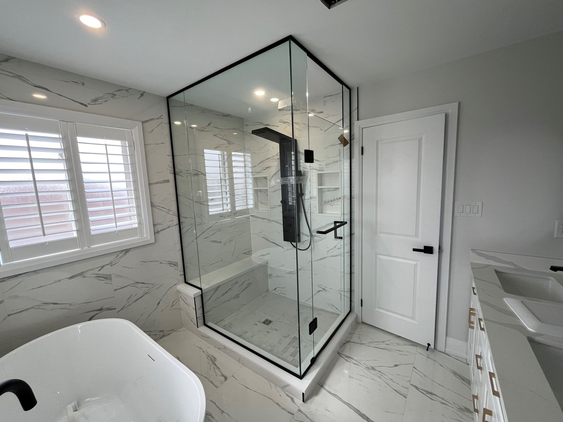 A bathroom with a walk in shower and a bathtub.