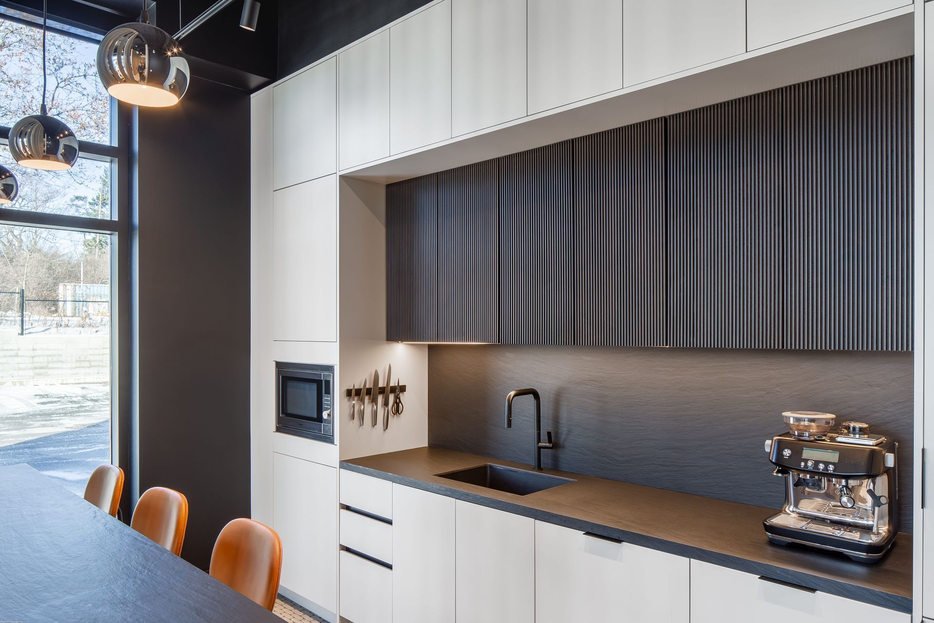 A kitchen with white cabinets and a coffee maker on the counter.