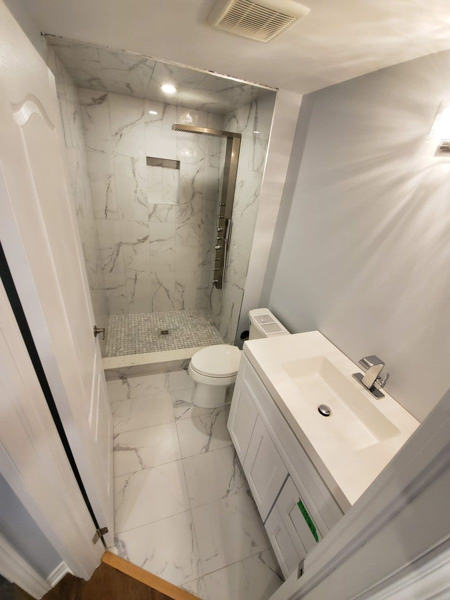 A bathroom with a toilet a sink and a shower