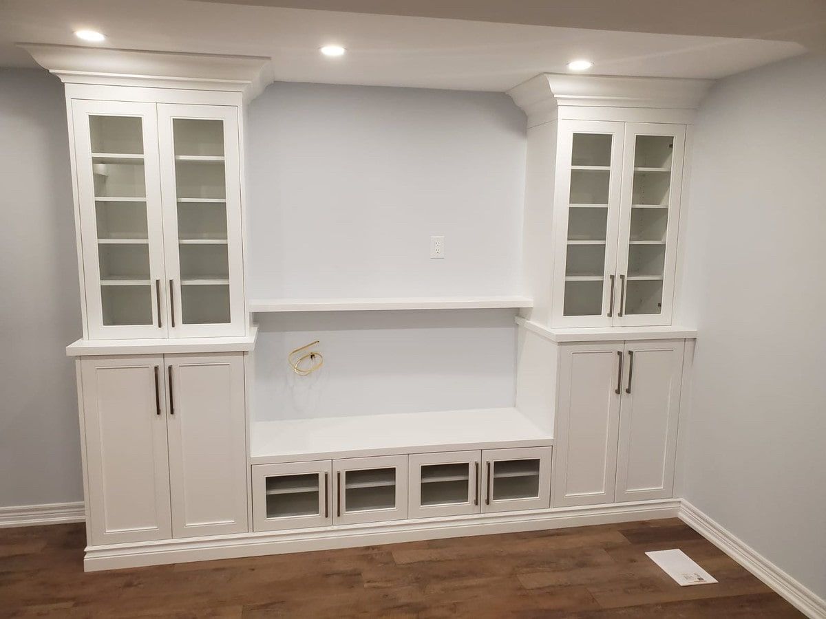 A living room with white cabinets and glass doors.