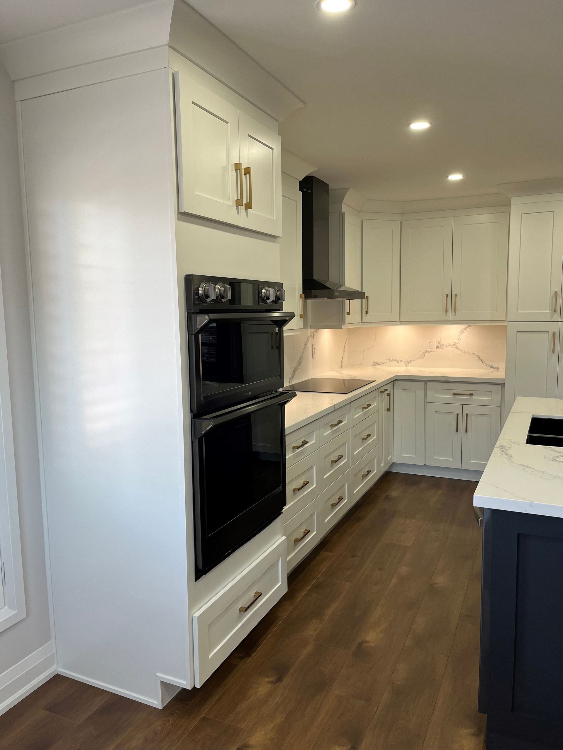 A kitchen with white cabinets and a black oven