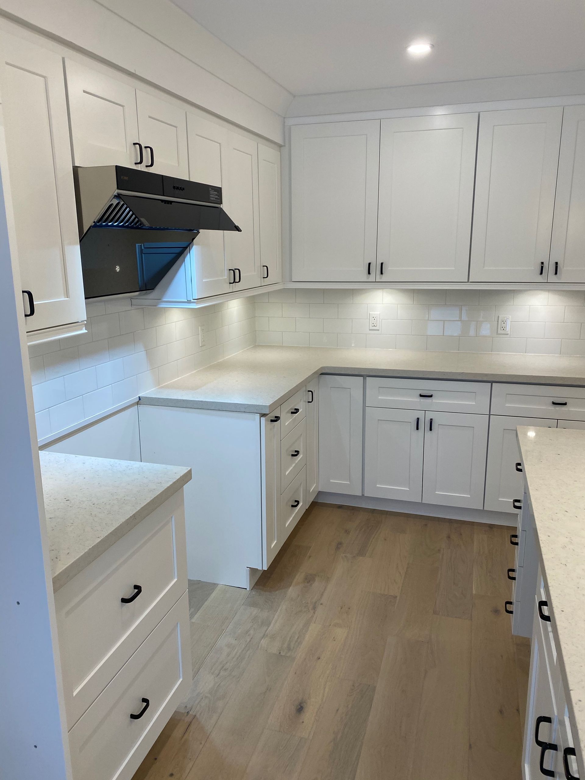A kitchen with white cabinets and granite counter tops