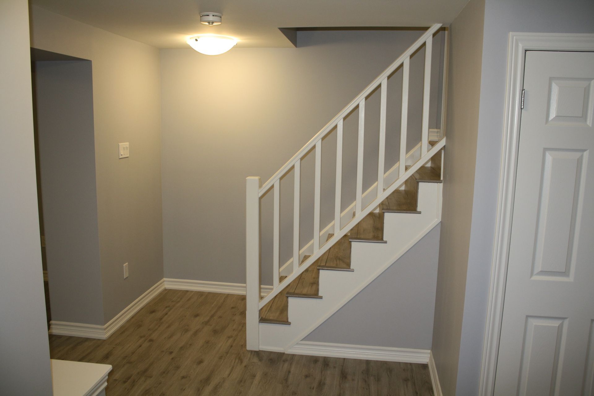 A hallway with stairs leading up to the second floor