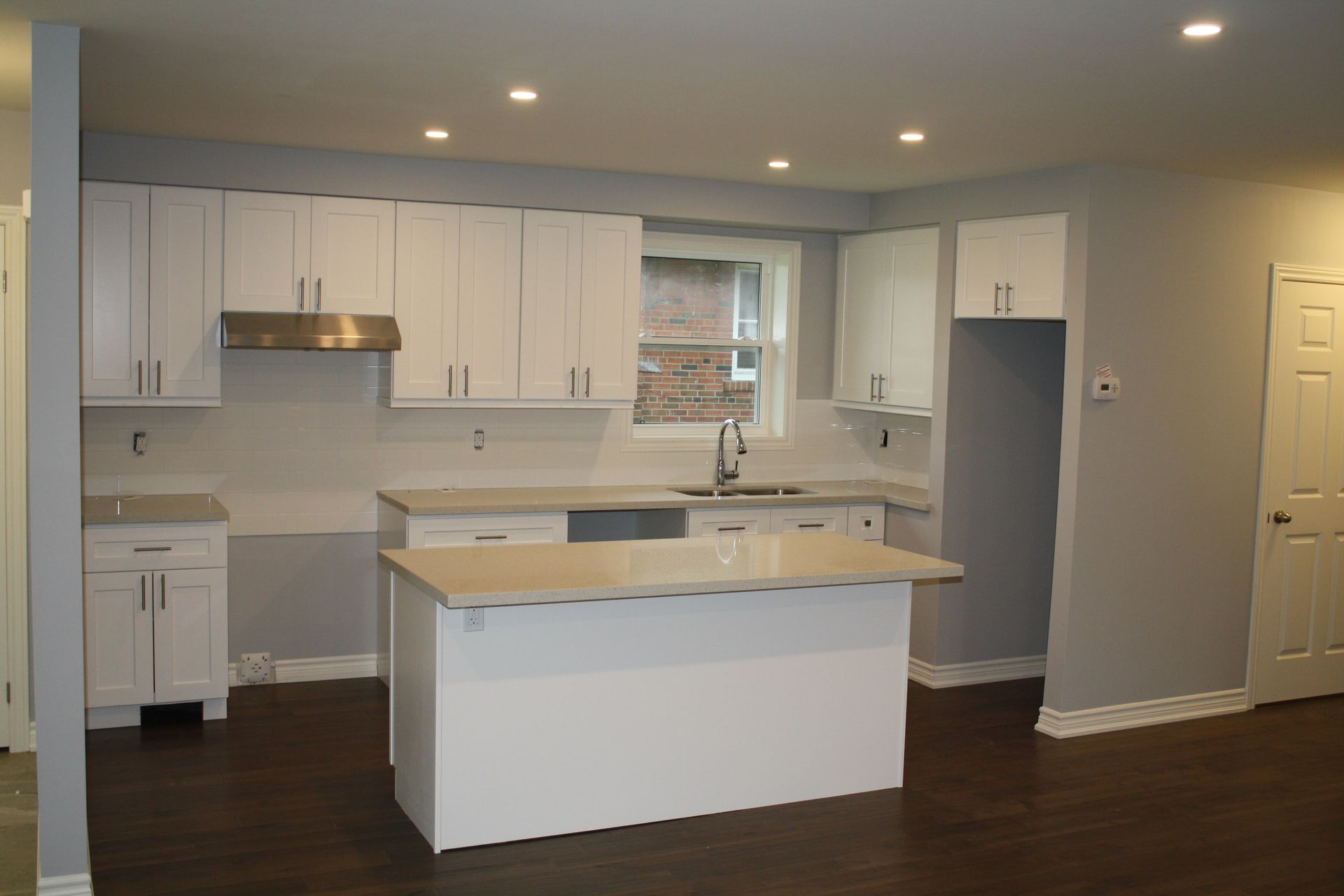 A kitchen with white cabinets and a large island